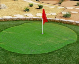 Back yard putting green with synthetic grass by Rising Sun Landscaping & Maintenance.